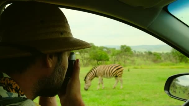 Turista Masculino Usando Chapéu Safári Tira Fotos Animais Uma Savana — Vídeo de Stock