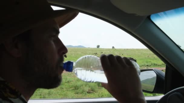 Hombre Turista Viajero Bebe Agua Vehículo Safari Sobre Fondo Avestruces — Vídeos de Stock