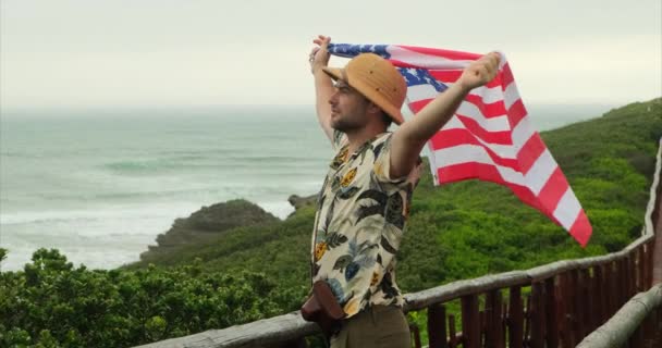 여행자는 국기를 자랑스럽게 있습니다 하이커 남자는 캘리포니아 해변에서 기념일 국기를 — 비디오