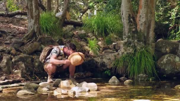 背着背包 身穿活跃的远足服装的游客住在山河瀑布边 享受大自然的美景 徒步旅行可以解渴 — 图库视频影像