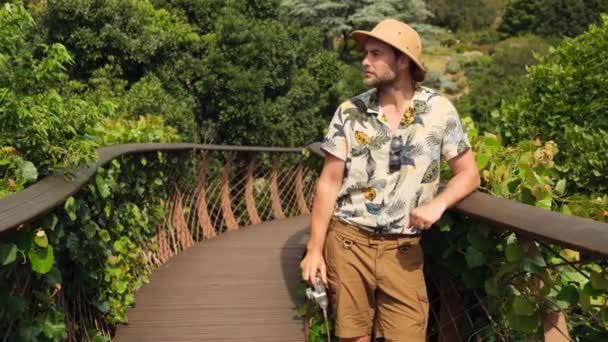 Safari Şapkalı Bir Erkek Gezgin Asma Köprüde Fotoğraf Çekiyor Sırt — Stok video