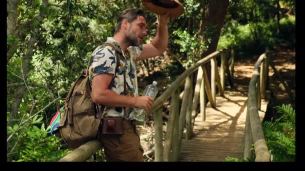 Şortlu Gömlekli Bir Erkek Turist Ormanda Plastik Bir Şişeden Içer — Stok video