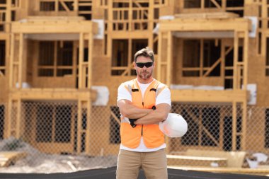 İnşaat alanındaki çatı ustası, Rıhtım inşaatında çalışıyor. Kameraya gülümseyen kasklı yakışıklı, genç bir müteahhit. Görevli inşaat işçisi. Müteahhit ve Tahta Ev Çerçevesi