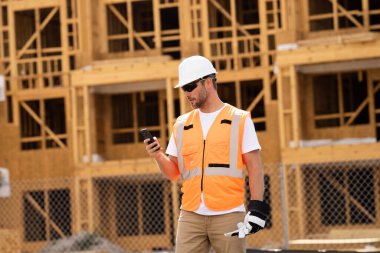 İnşaat alanındaki çatı ustası, Rıhtım inşaatında çalışıyor. Kameraya gülümseyen kasklı yakışıklı, genç bir müteahhit. Görevli inşaat işçisi. Müteahhit ve Tahta Ev Çerçevesi