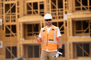 İnşaat alanındaki çatı ustası, Rıhtım inşaatında çalışıyor. Kameraya gülümseyen kasklı yakışıklı, genç bir müteahhit. Görevli inşaat işçisi. Müteahhit ve Tahta Ev Çerçevesi