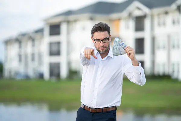 stock image Attractive man is holding cash money in one hand. Joyful man with banknotes of money in his hands. Big financial luck and success, profit and cash. Rich man hands holding cash money