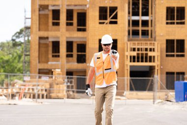 İnşaat alanındaki çatı ustası, Rıhtım inşaatında çalışıyor. Kameraya gülümseyen kasklı yakışıklı, genç bir müteahhit. Görevli inşaat işçisi. Müteahhit ve Tahta Ev Çerçevesi