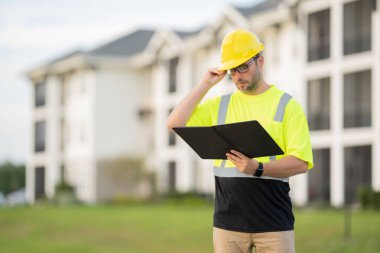 Yüksek görünüm donanımlı bir inşaat işçisi tozlu bir şantiyede güvenlik ve profesyonelliği vurguluyor