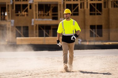 A construction worker in highvisibility gear emphasizes safety and professionalism at a dusty work site clipart