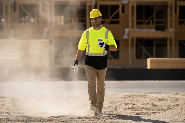 stock image A construction worker in highvisibility gear emphasizes safety and professionalism at a dusty work site