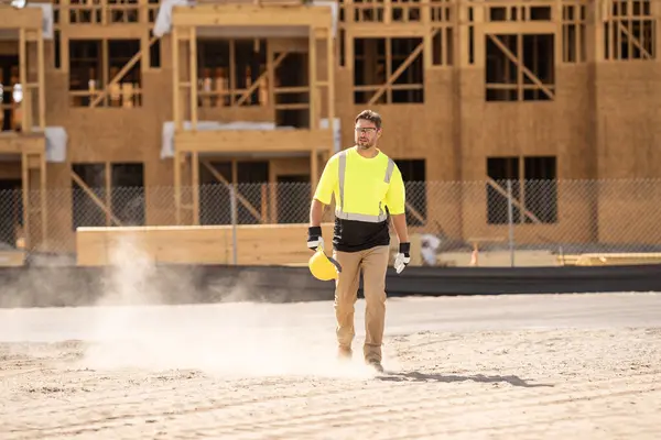 stock image A construction worker in highvisibility gear emphasizes safety and professionalism at a dusty work site