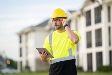Yüksek görünüm donanımlı bir inşaat işçisi tozlu bir şantiyede güvenlik ve profesyonelliği vurguluyor