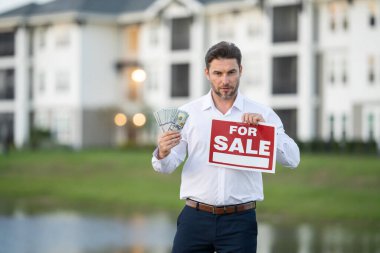 Elinde para tutan beyaz gömlekli bir adam. Emlakçı yeni evin anahtarını verdi. Kontrat imzalamadan önce emlakçı ve müşteri. Satılık ya da kira tabelası olan erkek emlakçı..