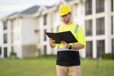 Yüksek görünüm donanımlı bir inşaat işçisi tozlu bir şantiyede güvenlik ve profesyonelliği vurguluyor