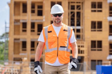 İnşaat alanındaki çatı ustası, Rıhtım inşaatında çalışıyor. Kameraya gülümseyen kasklı yakışıklı, genç bir müteahhit. Görevli inşaat işçisi. Müteahhit ve Tahta Ev Çerçevesi