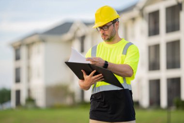 İnşaat işçisi inşaat alanında kahve molası veriyor. Miğferli bir inşaatçı. Şapkalı bir işçi. İnşaat miğferinde portre mekaniği işçisi. Mühendis ustabaşı veya tamirci..