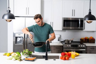 Profesyonel üniformalı modern şef. Kaşıkla tencereye çorba karıştıran erkek aşçının eline yakın plan. Yemek pişirme, aşçılık ve insan konsepti - erkek aşçı tencereli veya tencereli.