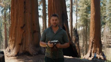 Ağacın yanında bir fotoğrafçı. Sequoia Ulusal Parkı 'ndaki dev Sequoia ağaçları. Yeni Zelanda 'nın Kuzey Adası yakınlarındaki Whakarewarewa Ormanı' nda fotoğraf çeken erkek fotoğrafçı.