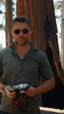 Ağacın yanında bir fotoğrafçı. Sequoia Ulusal Parkı 'ndaki dev Sequoia ağaçları. Yeni Zelanda 'nın Kuzey Adası yakınlarındaki Whakarewarewa Ormanı' nda fotoğraf çeken erkek fotoğrafçı.