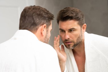 Kozmetik güzellik merkezi. Erkek kozmetik ürünleri. Yüz bakımı cilt bakımı ve güzellik kavramları. Kırışıklıkları olan yakışıklı yaşlı bir adam. Erkek, sağlıklı cilt ve kaplıca. Temiz ciltli son sınıf öğrencisi. Güzel erkek cilt bakımı.