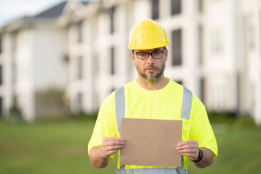 İnşaat işçisi inşaat alanında kahve molası veriyor. Miğferli bir inşaatçı. Şapkalı bir işçi. İnşaat miğferinde portre mekaniği işçisi. Mühendis ustabaşı veya tamirci..