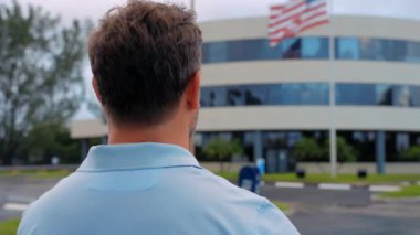 Adam ellerini Amerikan bayrağının önüne koyan bir kalp gösteriyor. Açık havada Amerikan bayrağı. Amerika Birleşik Devletleri bayrağını mavi gökyüzüne karşı tutuyor. 4 Temmuz Bağımsızlık Günü. Anma ve Gaziler Günü