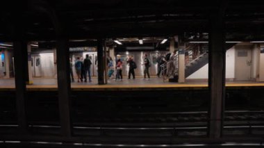 New York metro istasyonunda treni bekleyen bir sürü insan. New York 'ta metro yolculuğu. Manhattan Metro Tabelası. Yükseltilmiş Metro Treni ve New York City Skyline