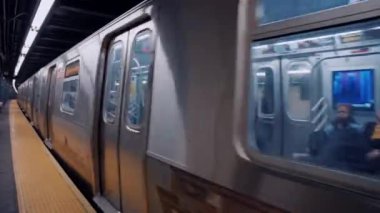 New York metro istasyonunda treni bekleyen bir sürü insan. New York 'ta metro yolculuğu. Manhattan Metro Tabelası. Yükseltilmiş Metro Treni ve New York City Skyline