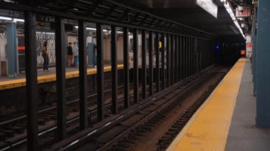 New York metro istasyonunda treni bekleyen bir sürü insan. New York 'ta metro yolculuğu. Manhattan Metro Tabelası. Yükseltilmiş Metro Treni ve New York City Skyline