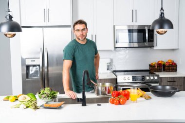 Profesyonel üniformalı modern şef. Kaşıkla tencereye çorba karıştıran erkek aşçının eline yakın plan. Yemek pişirme, aşçılık ve insan konsepti - erkek aşçı tencereli veya tencereli.