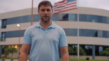 Korkmuş, şok olmuş yakışıklı adam. Şok olmuş, şaşkın bakışlı bir adam. Şok olmuş bir adam elleriyle ağzını kapatıyor. Adam Amerika 'da bayrağın yanındaki haberlere şaşırmış ya da üzülmüştü.