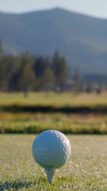 Yeşil sahadaki beyaz golf topu fotokopi uzayı ile aydınlık bir günde bulanık golf sahasında çekilecek. Spor, eğlence sektörü. Golf topu ve golf sopası yeşil çimlerin üzerinde.