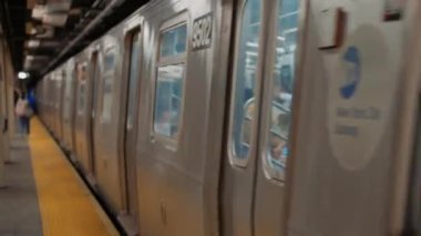 New York metro istasyonunda treni bekleyen bir sürü insan. New York 'ta metro yolculuğu. Manhattan Metro Tabelası. Yükseltilmiş Metro Treni ve New York City Skyline