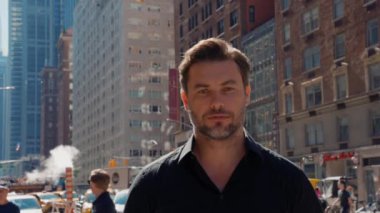 Kendine güvenen şık bir adam New York sokaklarındaki kameraya bakıyor. New York 'ta sokakta yürüyen bir iş adamı. New York 'ta Times Meydanı yakınlarındaki 5. Cadde' de bir erkek..