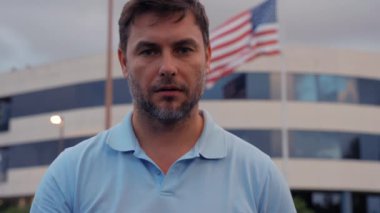 Korkmuş, şok olmuş yakışıklı adam. Şok olmuş, şaşkın bakışlı bir adam. Şok olmuş bir adam elleriyle ağzını kapatıyor. Adam Amerika 'da bayrağın yanındaki haberlere şaşırmış ya da üzülmüştü.
