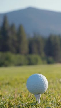 Yeşil sahadaki beyaz golf topu fotokopi uzayı ile aydınlık bir günde bulanık golf sahasında çekilecek. Spor, eğlence sektörü. Golf topu ve golf sopası yeşil çimlerin üzerinde.