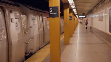 New York metro istasyonunda treni bekleyen bir sürü insan. New York 'ta metro yolculuğu. Manhattan Metro Tabelası. Yükseltilmiş Metro Treni ve New York Şehri Skyline 5. Cadde, 14 Eylül 2024.