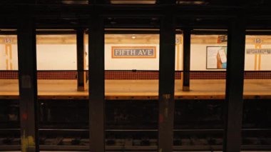 New York metro istasyonunda treni bekleyen bir sürü insan. New York 'ta metro yolculuğu. Manhattan Metro Tabelası. Yükseltilmiş Metro Treni ve New York Şehri Skyline 5. Cadde, 14 Eylül 2024.