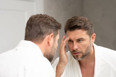 Kozmetik güzellik merkezi. Erkek kozmetik ürünleri. Yüz bakımı cilt bakımı ve güzellik kavramları. Kırışıklıkları olan yakışıklı yaşlı bir adam. Erkek, sağlıklı cilt ve kaplıca. Temiz ciltli son sınıf öğrencisi. Güzel erkek cilt bakımı.