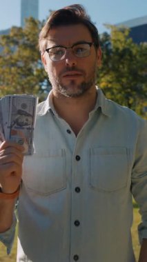 Parktaki gömlekli bir adam zula parasıyla para sayıyor. İş adamının eli para sayar. İş adamı elinde dolarları sayar. Yoksulluk kavramı, emeklilik ödemeleri, parayla emeklilik.