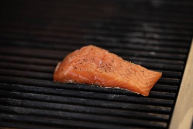 Şef açık havada ızgara somon fileto yapar, akşam yemeği için lezzetli deniz ürünleri hazırlar. Erkek aşçı taze balığı dikkatle tutar. Sahne açık havada yaz yemeklerini, tatlarını ve sağlıklı yaşam tarzlarını ön plana çıkarıyor.