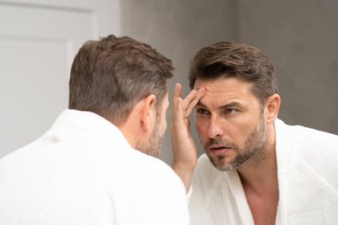 Kozmetik güzellik merkezi. Erkek kozmetik ürünleri. Yüz bakımı cilt bakımı ve güzellik kavramları. Kırışıklıkları olan yakışıklı yaşlı bir adam. Erkek, sağlıklı cilt ve kaplıca. Temiz ciltli son sınıf öğrencisi. Güzel erkek cilt bakımı.