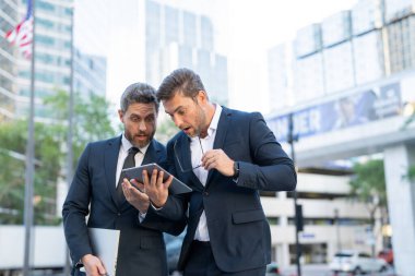 İki yönetici şehirdeki bir tabletten haberleri kontrol ederken şoka girmiş. Takım elbiseli erkek işadamları korku ve stresle tepki verir. Sahne siyaseti, Amerikan ekonomisini, finans ve piyasa çöküşünü vurguluyor.