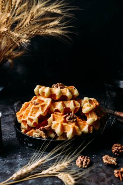 Koyu arkaplanda bal ve fındıklı Belçika waffle 'ları