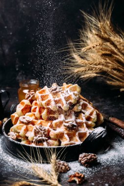 Koyu arkaplanda bal ve fındıklı Belçika waffle 'ları