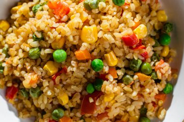 Bulgur with vegetables in a white plate close-up