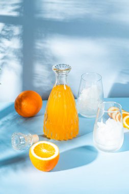 Mavi arka planda buzlu taze portakal suyu. turuncu kokteyl