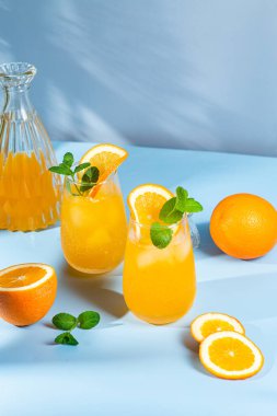 Mavi arka planda buzlu taze portakal suyu. turuncu kokteyl