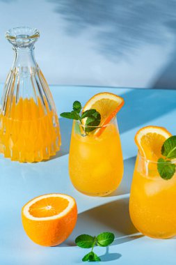 Mavi arka planda buzlu taze portakal suyu. turuncu kokteyl