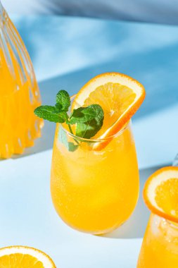 Mavi arka planda buzlu taze portakal suyu. turuncu kokteyl